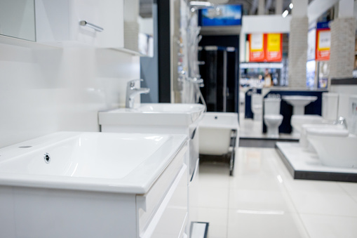 Ukraine, Kyiv- December 19, 2019: showroom with different white washbasins hanging on a wall at furniture hardware store.
