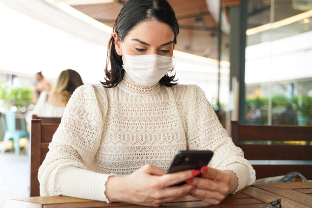 istock Woman uses smartphone while sitting outdoors. 1269750857