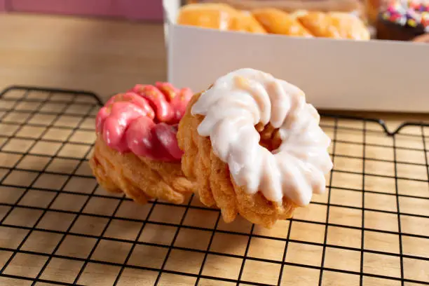A view of frosted cruller donuts, in a still life setting.