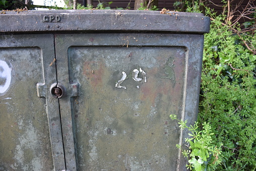 number 29 painted on flaking metal door of a utility cabinet, electricity board or telecom