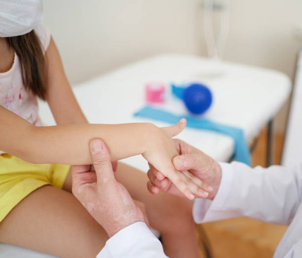 handgelenk-massage. ein männlicher massagetherapeut setzt einen empfindlichen punkt auf die hand eines kindes. - arthritis stock-fotos und bilder