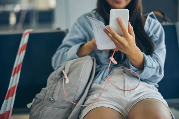 istock Good looking female with ticket and modern device sitting on the bench 1269758140