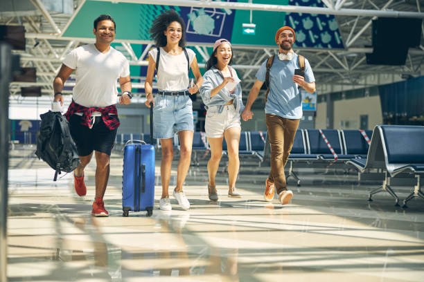 istock Happy smiling tourist group running to the gate for catch a flight 1269758184