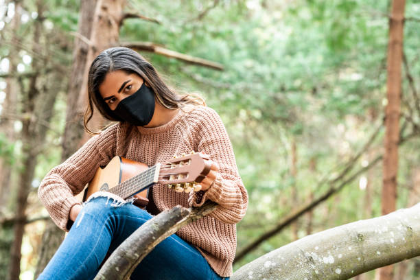 istock young woman plays her guitar in the forest 1269758362