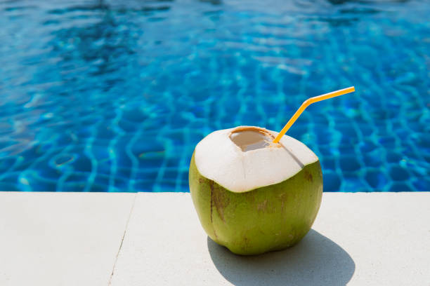 istock Juicy tropical coconut on a blue pool background 1269758399