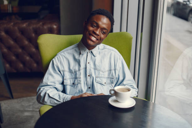 istock Black man sitting in a cafe and drinking a coffee 1269759169