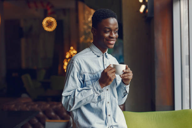 istock Black man standing in a cafe and drinking a coffee 1269759178