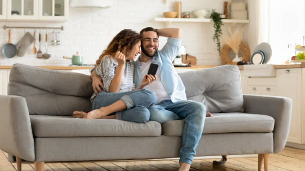 istock Smiling man and woman hugging using smartphone reading joke. 1269761465