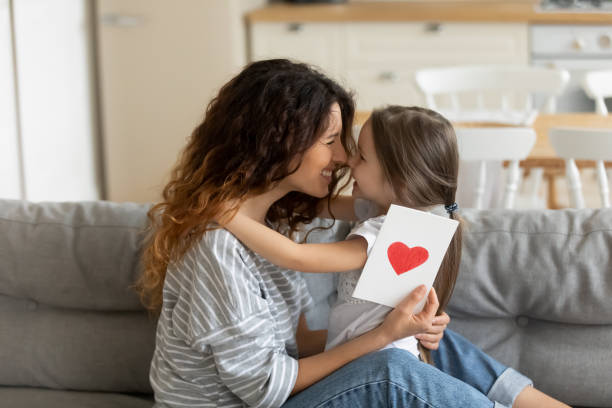 istock Close up young mother holding gift postcard with heart. 1269761479