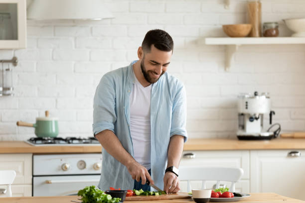 istock Happy bearded man chopping vegetables for cooking salad. 1269761497