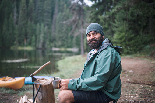 Portrait of cheerful adult male while on camping at mountains