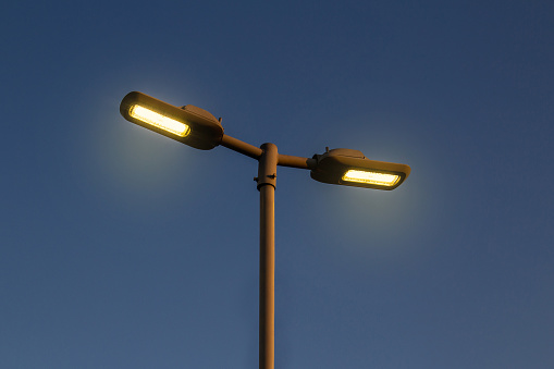 Street lamp post with lights on.