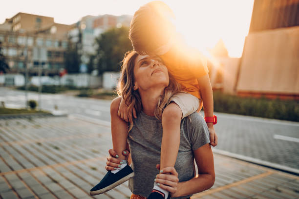 公共の公園で遊ぶ母と息子、スカテボードを運転 - child women outdoors mother ストックフォトと画像