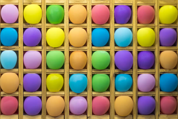 boules multicolores gonflables dans des cellules en bois pour jouer aux fléchettes, arrière-plan - rubber dart photos et images de collection