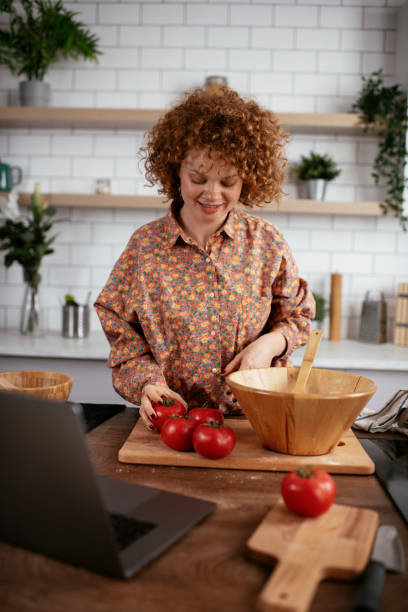 istock Young woman is reading a recipe while cooking. 1269786200
