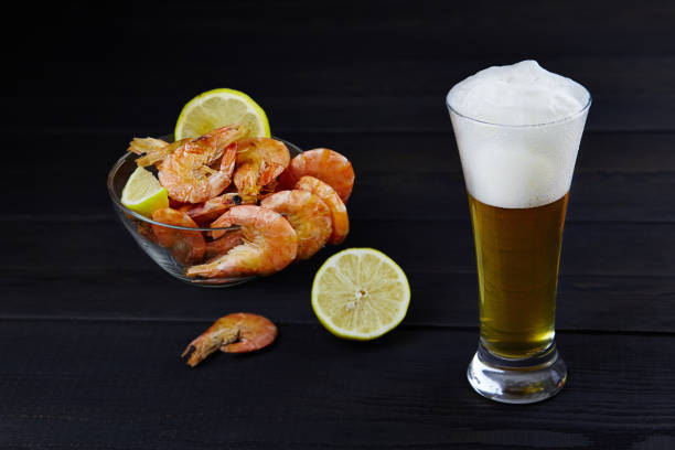 Homemade lager beer with shrimps on a dark wooden rustic background