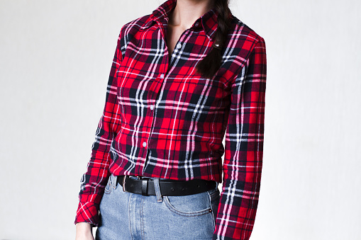 young woman with braid wearing red plaid shirt and jeans