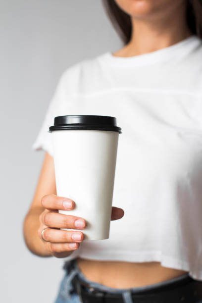 istock a disposable coffee cup in young womans hand 1269790087