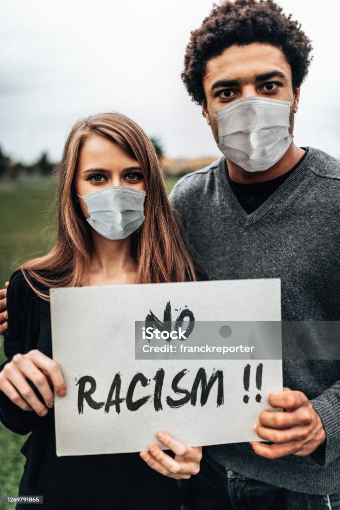 couple holding a board during a protest man holding a board during a protest Anti-racism Stock Photo