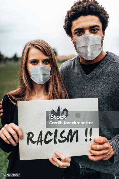 Couple Holding A Board During A Protest Stock Photo - Download Image Now - Anti-racism, Couple - Relationship, Protest