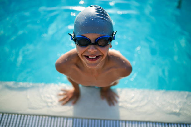 маленький мальчик, наслаждаясь плаванием в бассейне - child swimming pool swimming little boys стоковые фото и изображения
