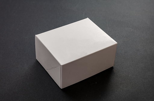 Package box rectangle, blank advertise template for products packaging. White color empty closed cardboard container against black background