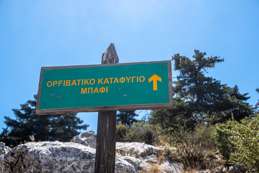 Parnitha national park, Greece. Directional green sign for Mpafi shelter by hiking, Tourist destination for activity, hiking to the peak, adventure at wild nature background.