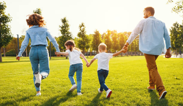istock Anonymous happy family running back in park in summer evening 1269795418