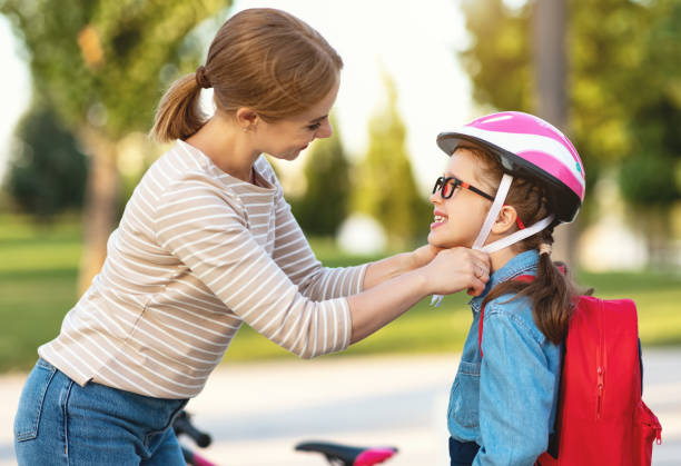 istock Mother fastening helmet on daughter 1269796759