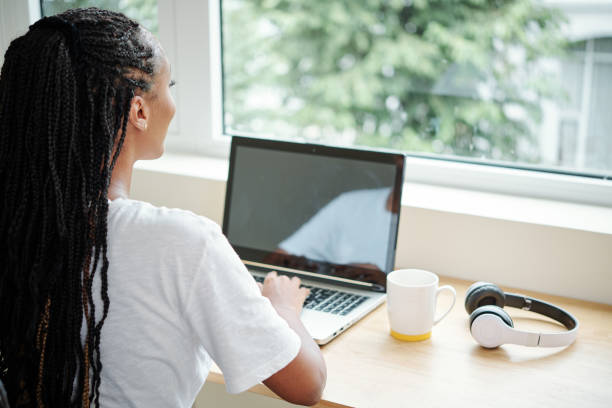 istock Pensive woman looking through window 1269798958