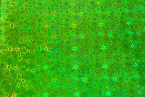 Blurred green trendy backdrop with stars. Bright holographic foil background. Colorful blue, red, purple background. Flat lay