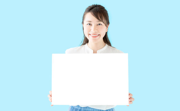 Young businesswoman holding a sign board. Young businesswoman holding a sign board. flipchart stock pictures, royalty-free photos & images