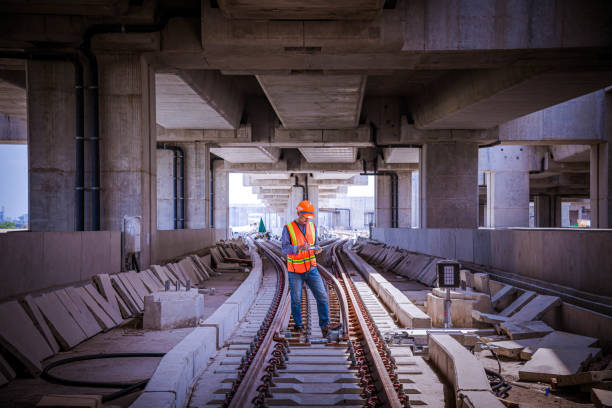 Portrait engineer under inspection and checking construction process railway switch and checking work on railroad station .Engineer wearing safety uniform and safety helmet in work. ingeniero de retratos bajo inspección y comprobación del proceso de construcción interruptor ferroviario y el trabajo de verificación en la estación de ferrocarril. ingeniero que lleva uniforme de seguridad y casco de seguridad en el trabajo.