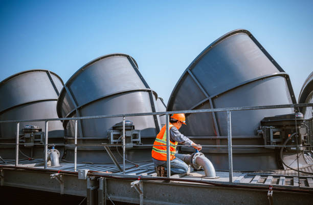 istock engineer under checking the industry cooling tower air conditioner is water cooling tower air chiller HVAC of large industrial building to control air system. 1269801135