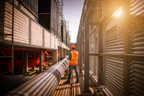 istock engineer under checking the industry cooling tower air conditioner is water cooling tower air chiller HVAC of large industrial building to control air system. 1269801139