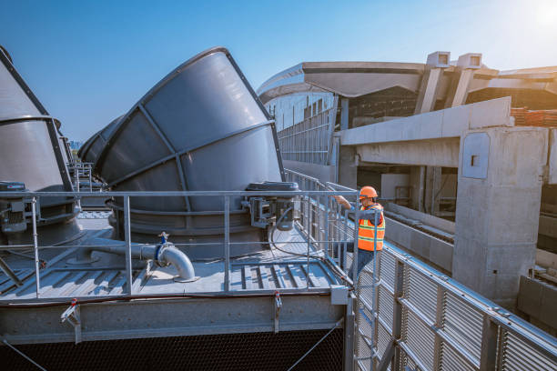 istock engineer under checking the industry cooling tower air conditioner is water cooling tower air chiller HVAC of large industrial building to control air system. 1269801140