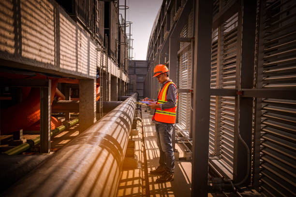 istock engineer under checking the industry cooling tower air conditioner is water cooling tower air chiller HVAC of large industrial building to control air system. 1269801143