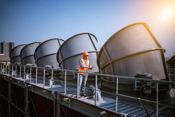 istock engineer under checking the industry cooling tower air conditioner is water cooling tower air chiller HVAC of large industrial building to control air system. 1269801144