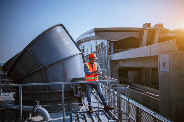 istock engineer under checking the industry cooling tower air conditioner is water cooling tower air chiller HVAC of large industrial building to control air system. 1269801166