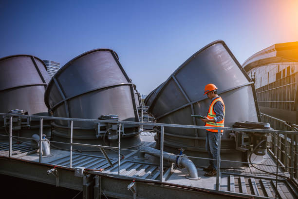 istock engineer under checking the industry cooling tower air conditioner is water cooling tower air chiller HVAC of large industrial building to control air system. 1269801213