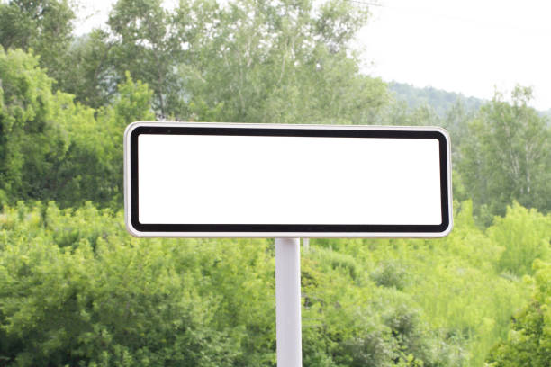istock White road sign with an empty field for text or a pointer against a green forest background. 1269807829