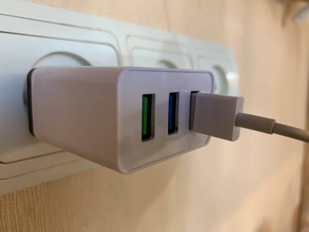 istock charger with 3 USB ports in the socket. 1 port is occupied by a charging cable 1269807933