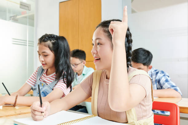 istock Schoolgirl raising hand 1269809538