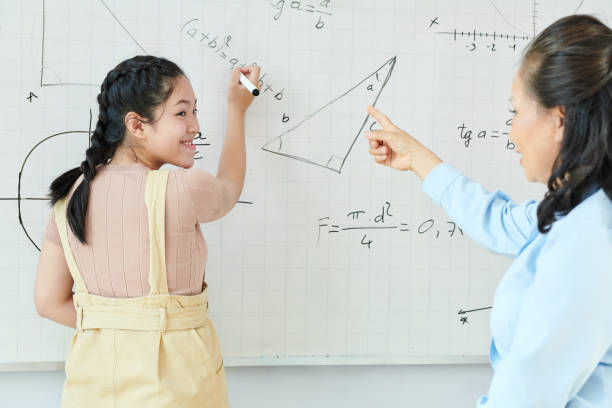istock Schoolgirl writing equation on whiteboard 1269809548