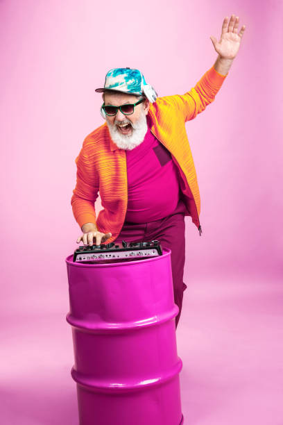 istock Senior hipster man wearing eyeglasses posing on pink background. Tech and joyful elderly lifestyle concept 1269810620