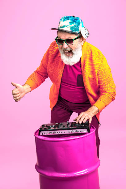 istock Senior hipster man wearing eyeglasses posing on pink background. Tech and joyful elderly lifestyle concept 1269810623