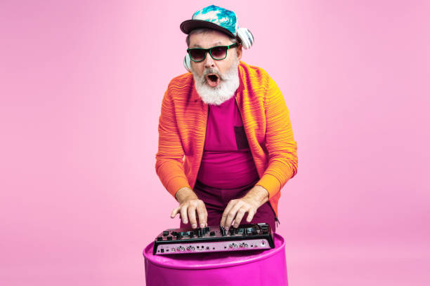 istock Senior hipster man wearing eyeglasses posing on pink background. Tech and joyful elderly lifestyle concept 1269810628