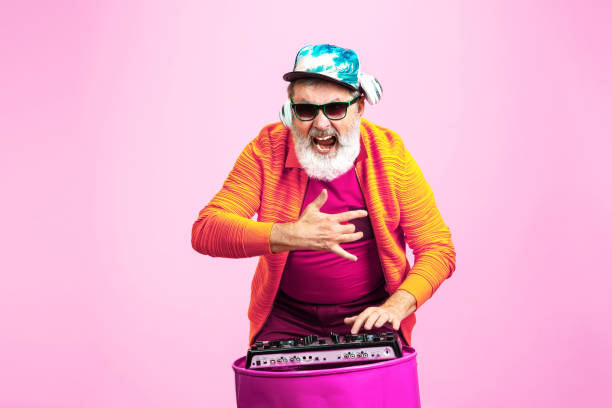 istock Senior hipster man wearing eyeglasses posing on pink background. Tech and joyful elderly lifestyle concept 1269810631