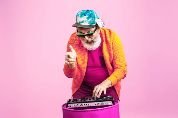 istock Senior hipster man wearing eyeglasses posing on pink background. Tech and joyful elderly lifestyle concept 1269810633