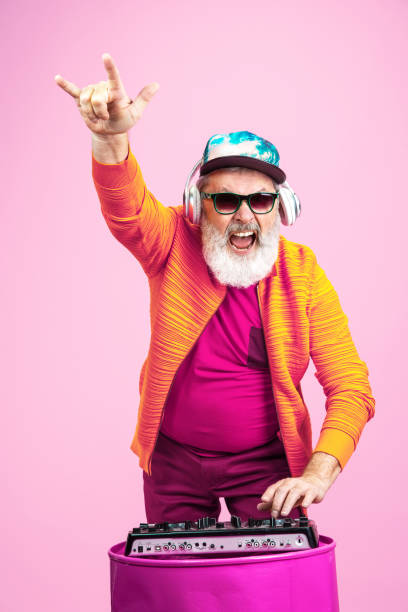 istock Senior hipster man wearing eyeglasses posing on pink background. Tech and joyful elderly lifestyle concept 1269810634